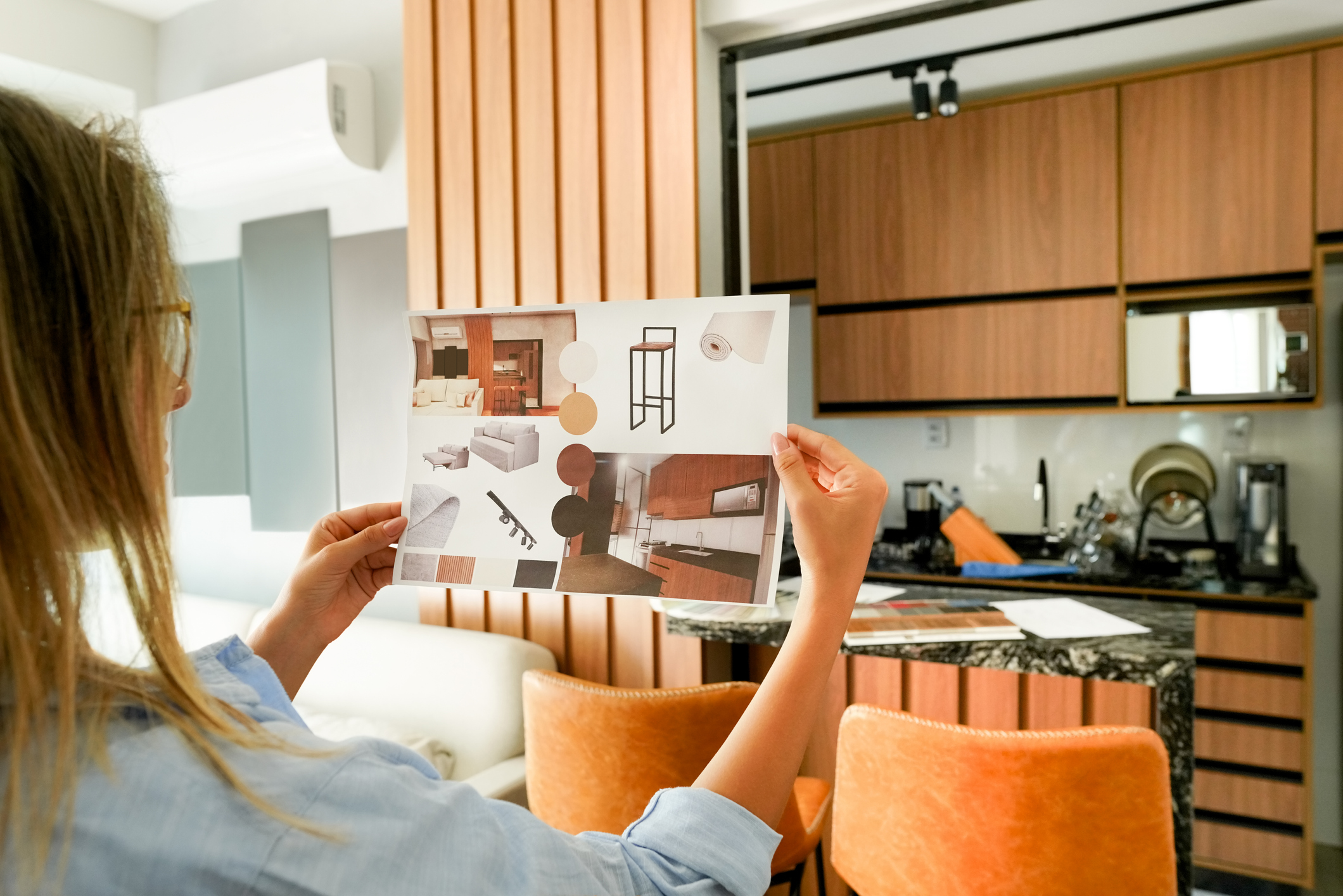 An interior designer holding up a design board for a dining room 