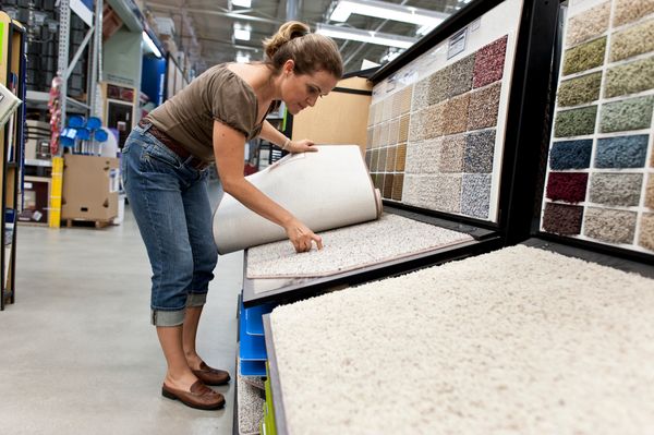 A woman evaluating carpeting 