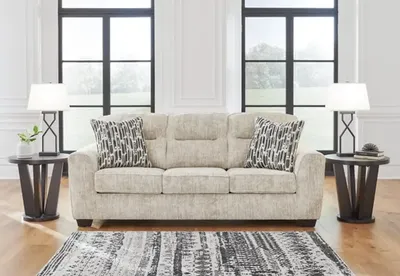 Front view of the Signature Design by Ashley Lonoke collection sofa with décor 