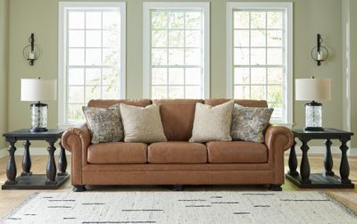 Front view of the Signature Design by Ashley Carianna collection sofa with décor 
