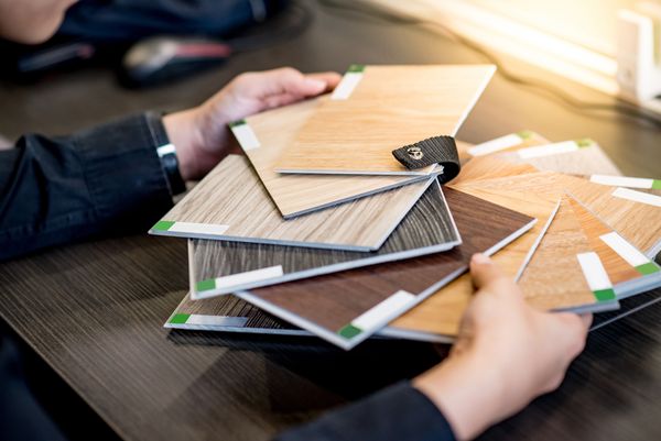 A person reviewing vinyl plank floor samples 