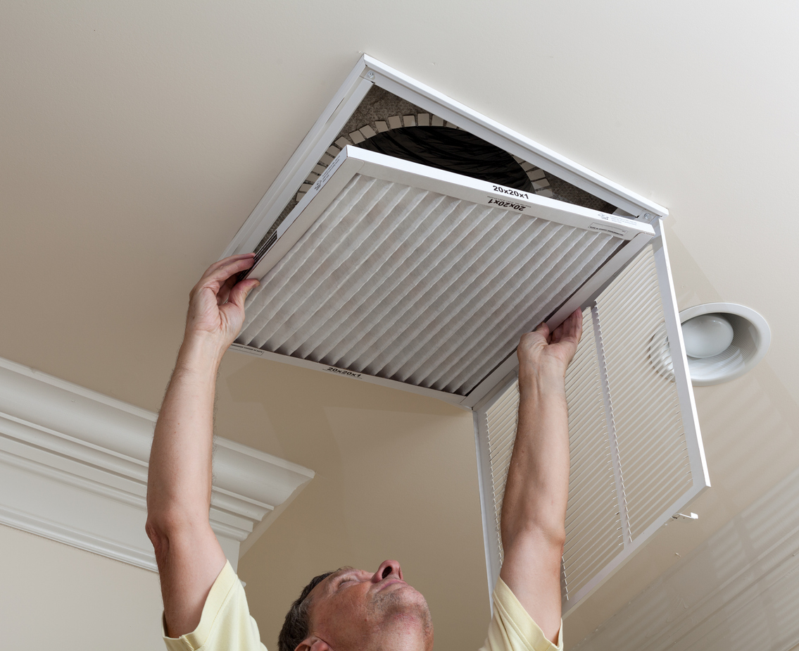 elderly man replacing an air vent filter