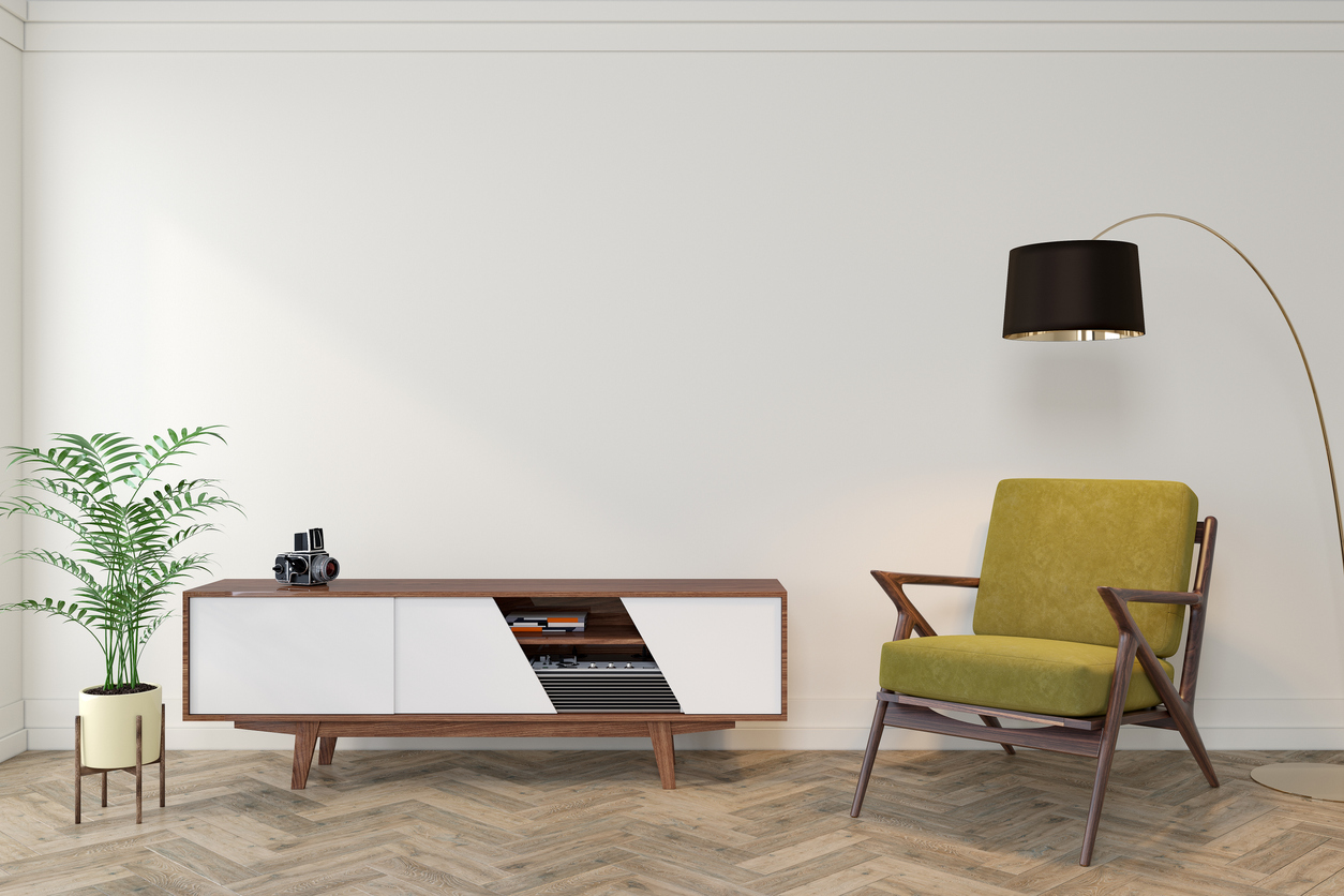 a green chair with a white tv stand and black lamp
