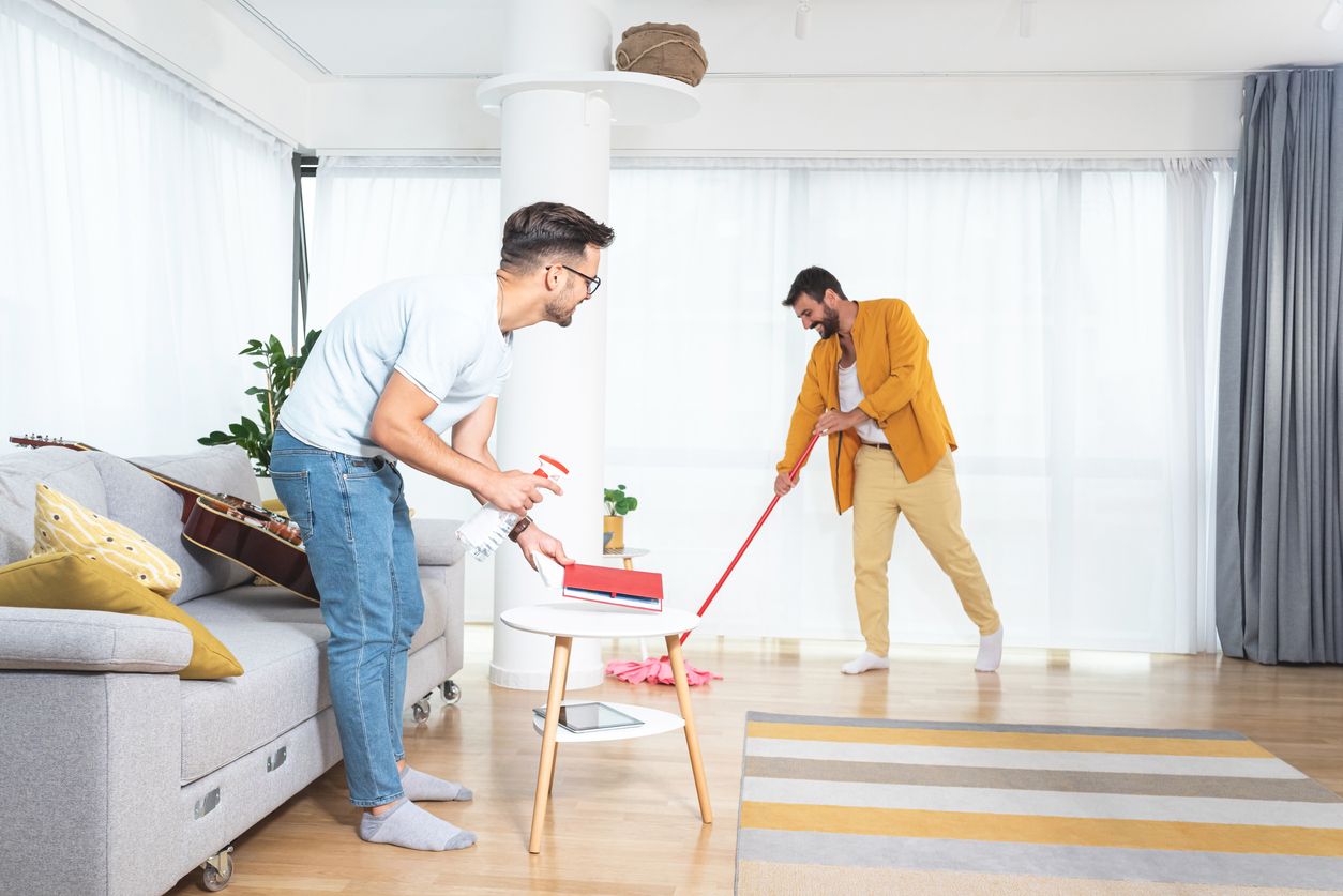 two men mop and clean their living room 