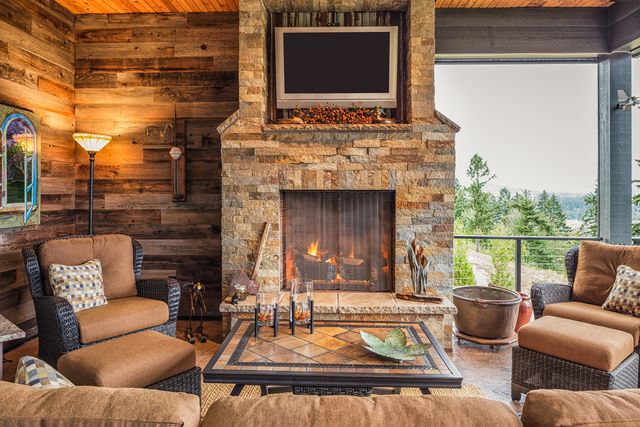 Front view of a rustic living room with a large stone fireplace