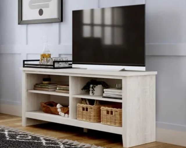 view of a tv on a white tv stand in a modern living room against a white wall