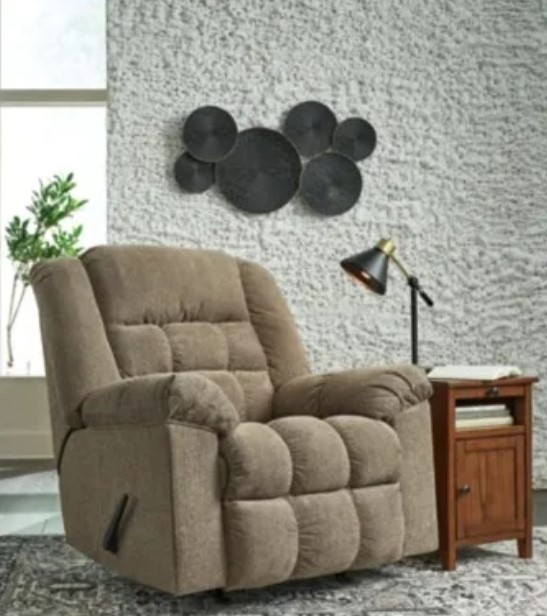 Ashley recliner sits in front of a grey stucco wall in a modern living room