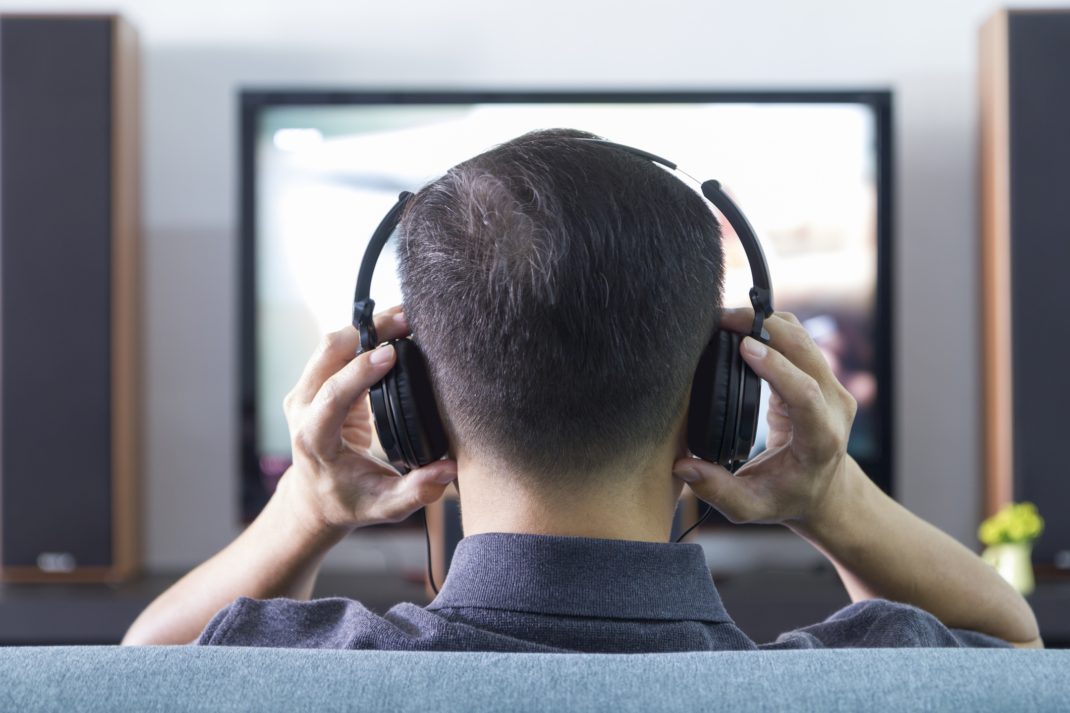 man with gaming headphones sitting in front of the screen