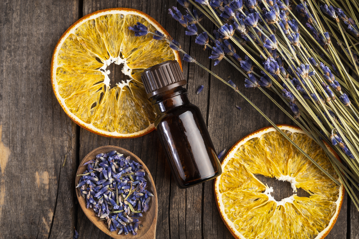 dehydrated lemon slices, lavender, and an apothecary vile on a wood surface