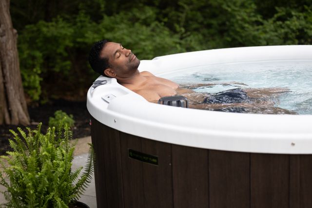 front view of a man leaning back and relaxing in a hot tub