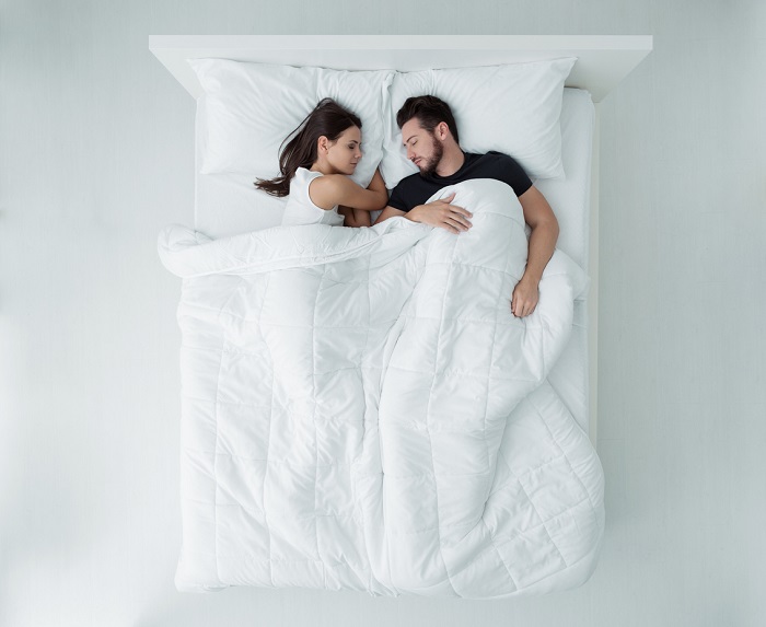 Couple relaxing and sleeping in bed.