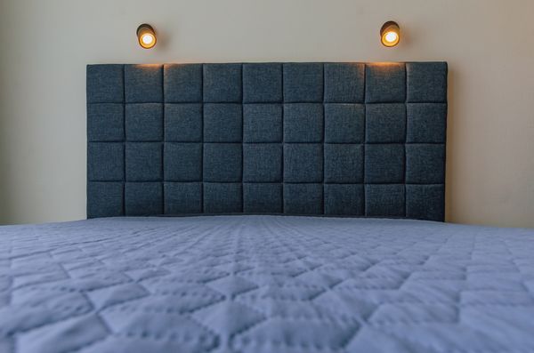 A blue wall mounted headboard and mattress