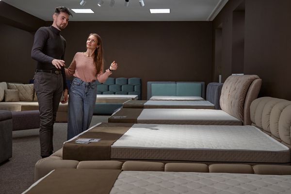 A man and a woman inspecting mattresses in a showroom 