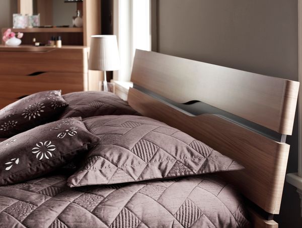A close-up of a modern headboard with bedding 