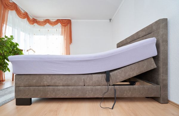 A lifted adjustable mattress and base in a bedroom 