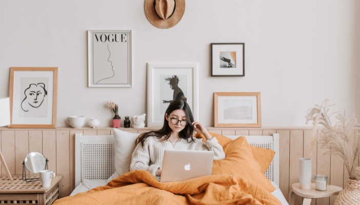 Woman sitting comfortable in bed with a comforter around her