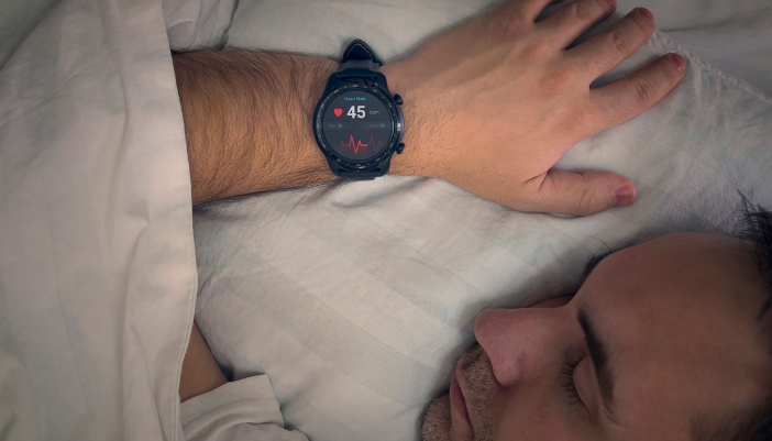 Man sleeping with a smartwatch showing his resting heartrate