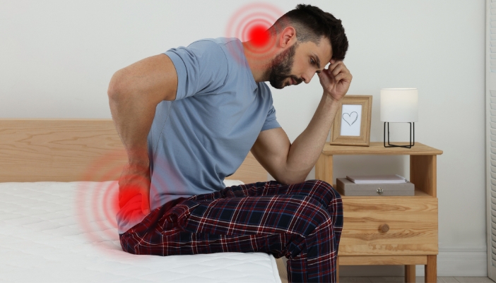Man waking up with neck and back pain from an insufficient mattress