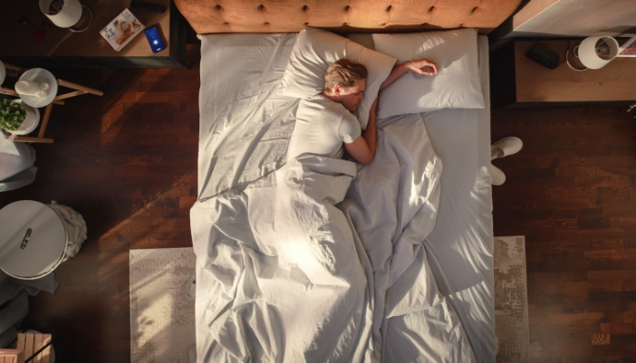 Man sleeping during the day with an alarm set on his phone