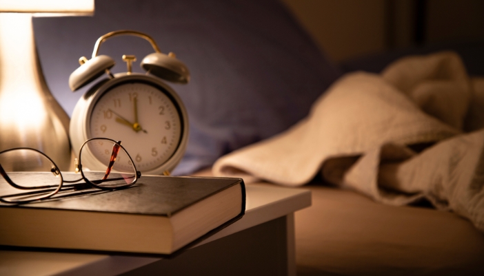 A cool and dark bedroom with a bedside lamp, perfect for reading