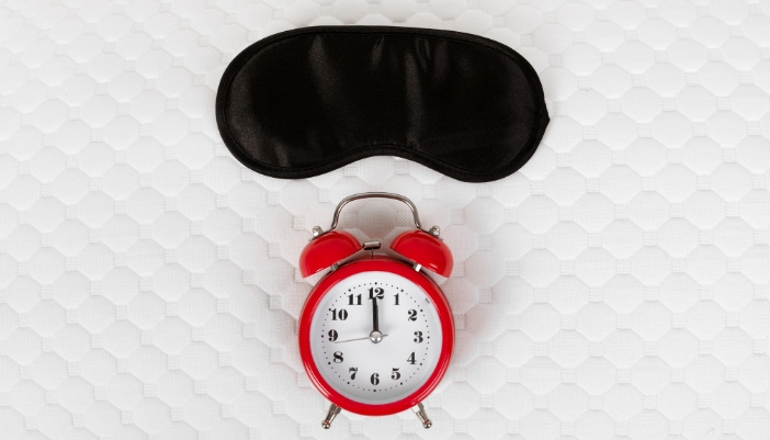 Concept image of sleep aids with a mask and an alarm