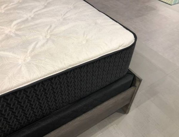 close view of the corner of a mattress on a box spring and bed