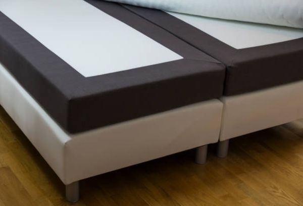 close up view of a split box spring setup on a bed frame