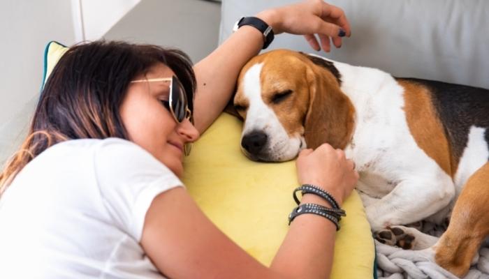 Woman with sunglasses laying down next to dog