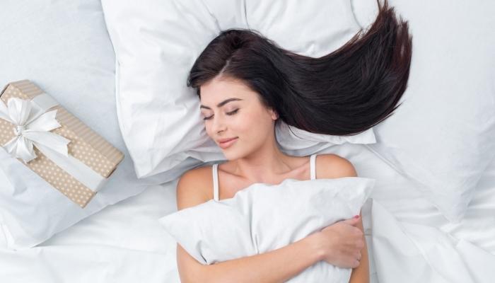 Woman in tank top smiling while sleeping