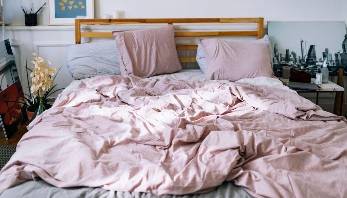 empty bed with pink pillows and duvet