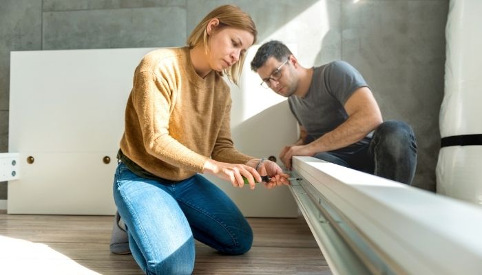 A woman and man assembling bed foundation