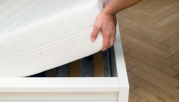 hands lifting a mattress