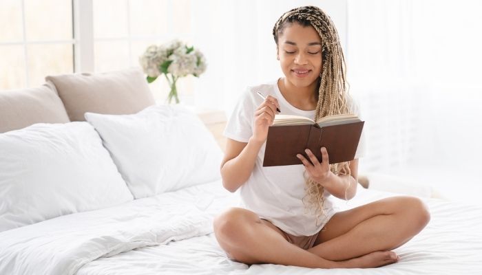 woman writing in notebook before bed