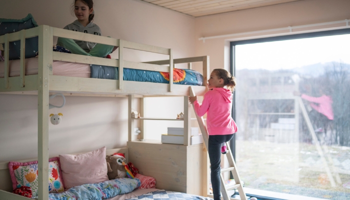 Little girl climbing up to the top bunk using the safety ladder
