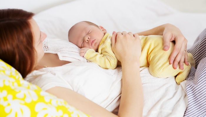 Newborn sleeping with his mom