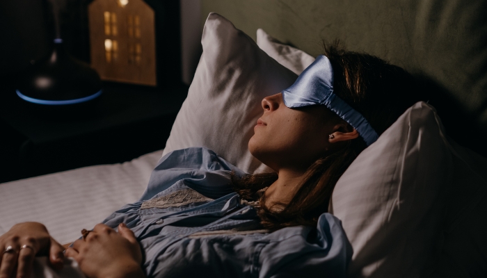Woman with eye mask in a dark room, deep asleep