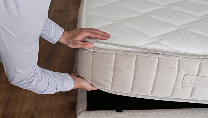 Closeup of mattress being placed on foundation