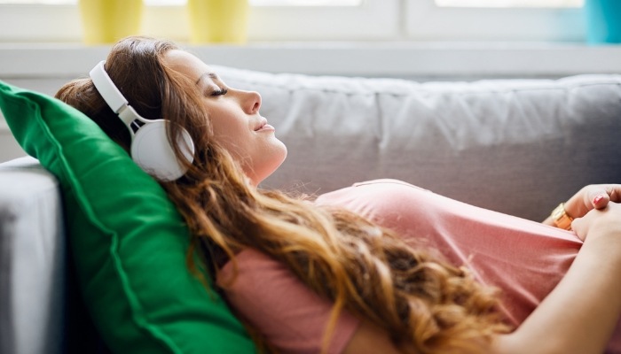 Woman relaxing on couch with music
