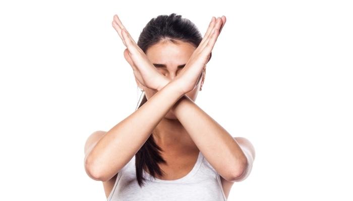 Woman making an X-shape with her arms