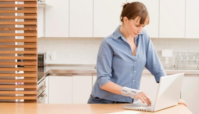 Woman typing on laptop with wrist guard