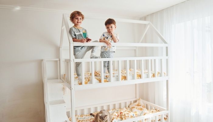 Two young boys standing on bunkbed