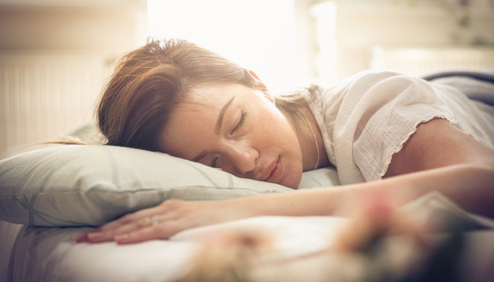 Woman sleeping on her stomach, while adequately supported
