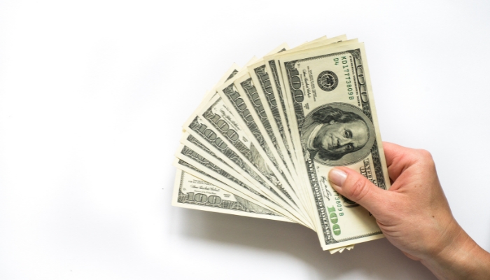 Closeup of hand holding several hundred dollars