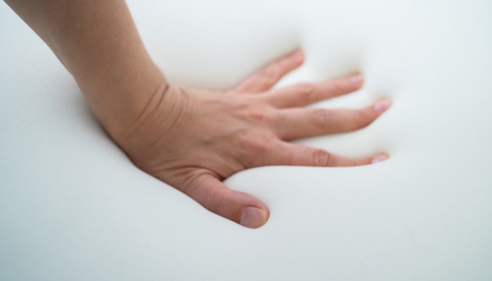 Hand testing out the comfort of the mattress