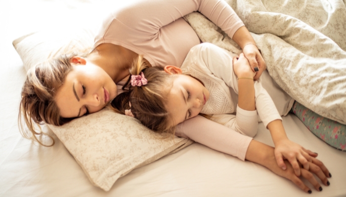 Mother and child sleeping peacefully in bed