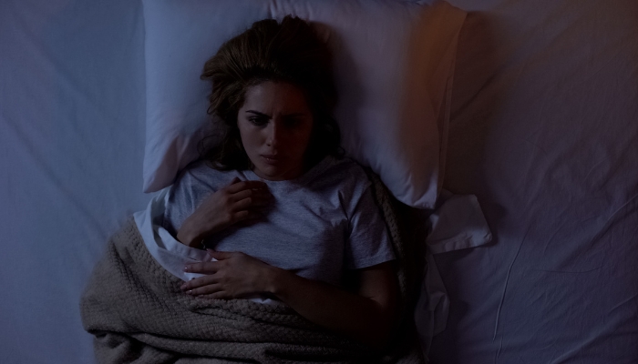 Woman waking up from a nightmare and can't go back to sleep