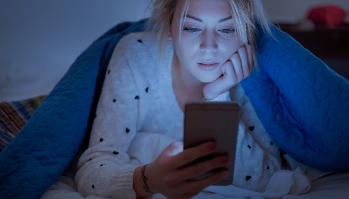 Woman staying up looking at her phone