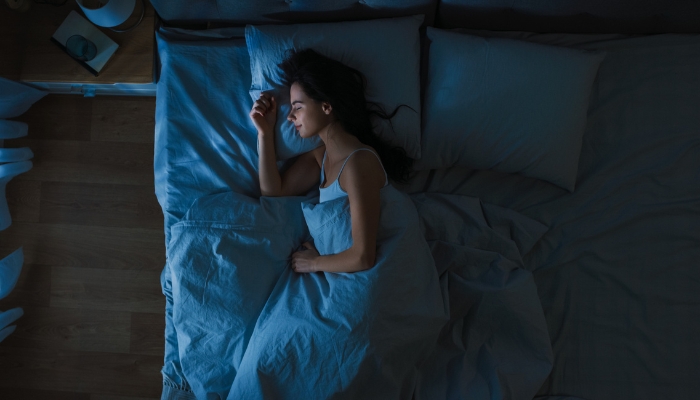 Woman sleeping in cool, quiet bedroom
