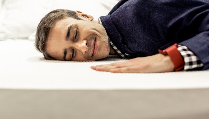 Man smiling as he lays on a memory foam bed