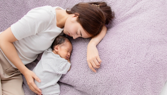 A new mom co-sleeping with her infant
